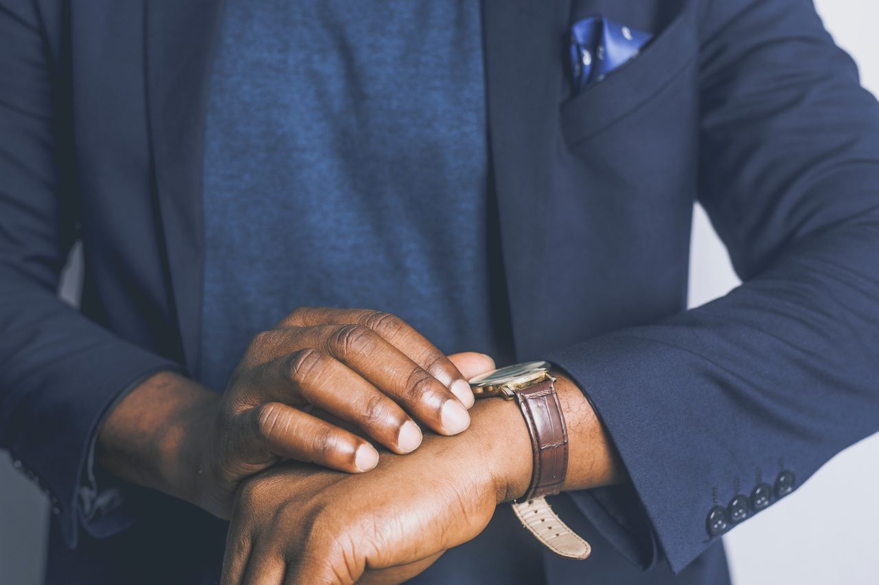 A man with a leather watch checks the time.