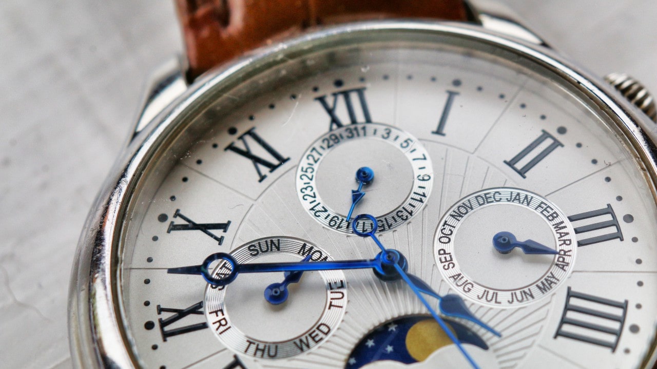 A close-up of an elegant luxury watch with chronograph complications.