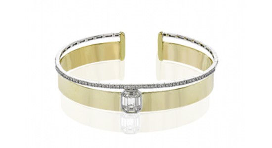 a mixed metal cuff bracelet featuring a large diamond at its center