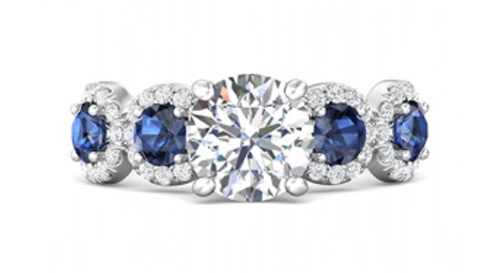 a white gold engagement ring with a round cut center stone and blue accent stones