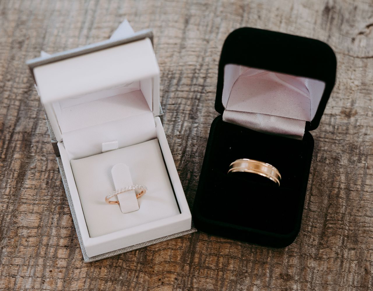 White and black ring boxes with gold wedding bands for the bride and groom