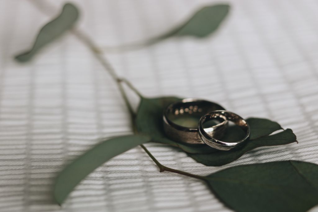 Two gold wedding bands on the leaves