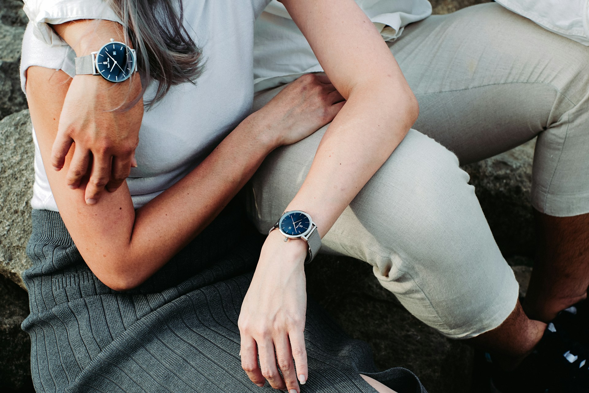 a couple embracing outside wearing the same silver and blue watch