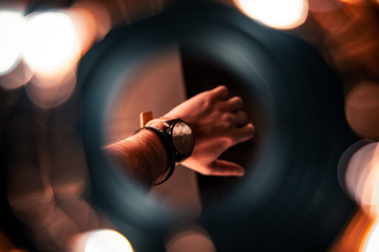 A view of a man’s watch through a lens.