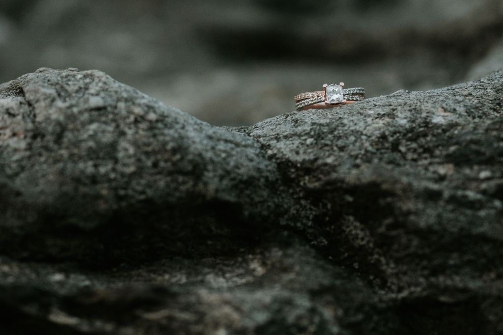 An elegant shot of a split shank two-tone engagement ring displayed on a rock.